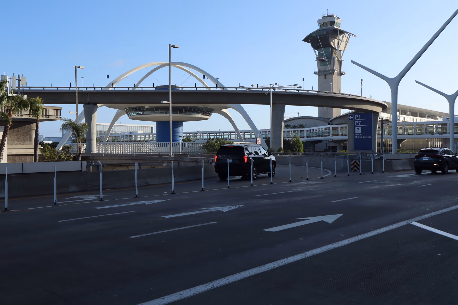 VIP City Rides black SUV driving past the LAX Theme Building and control tower at Los Angeles International Airport