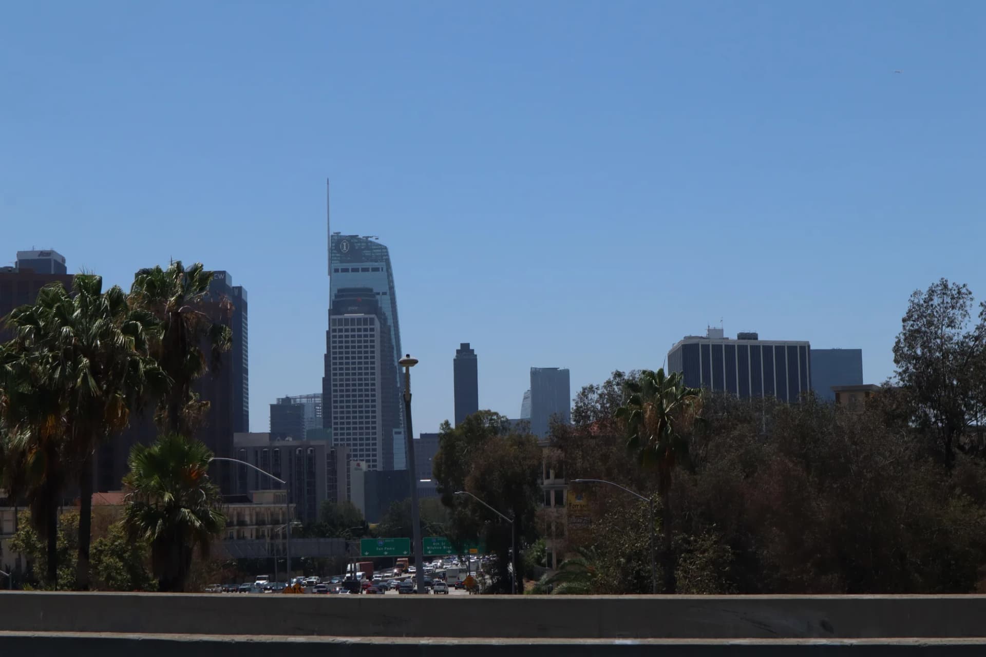 The Downtown Los Angeles skyline seen past palm trees in daytime