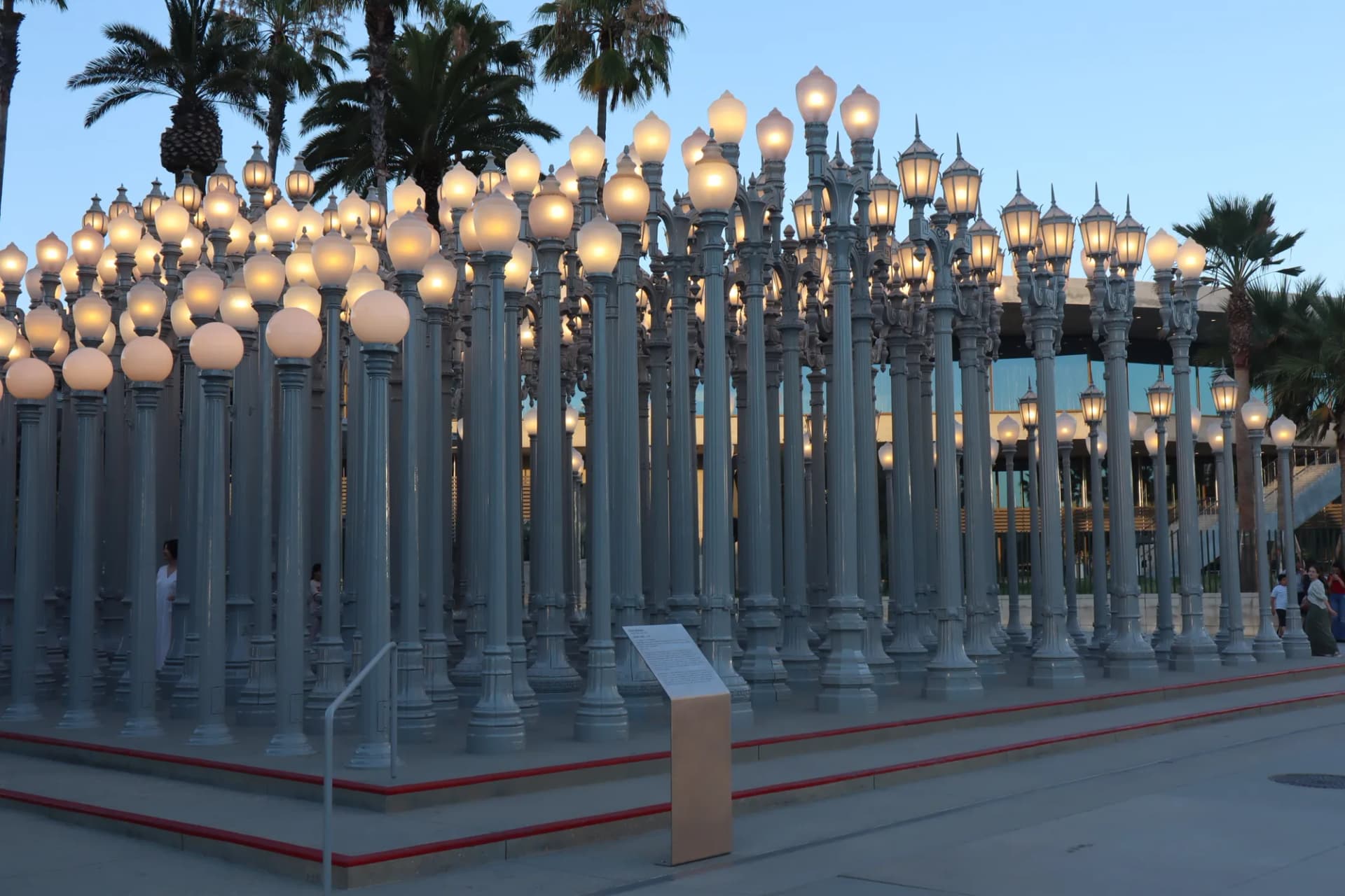 The Urban Light lamppost installation at LACMA glowing at dusk