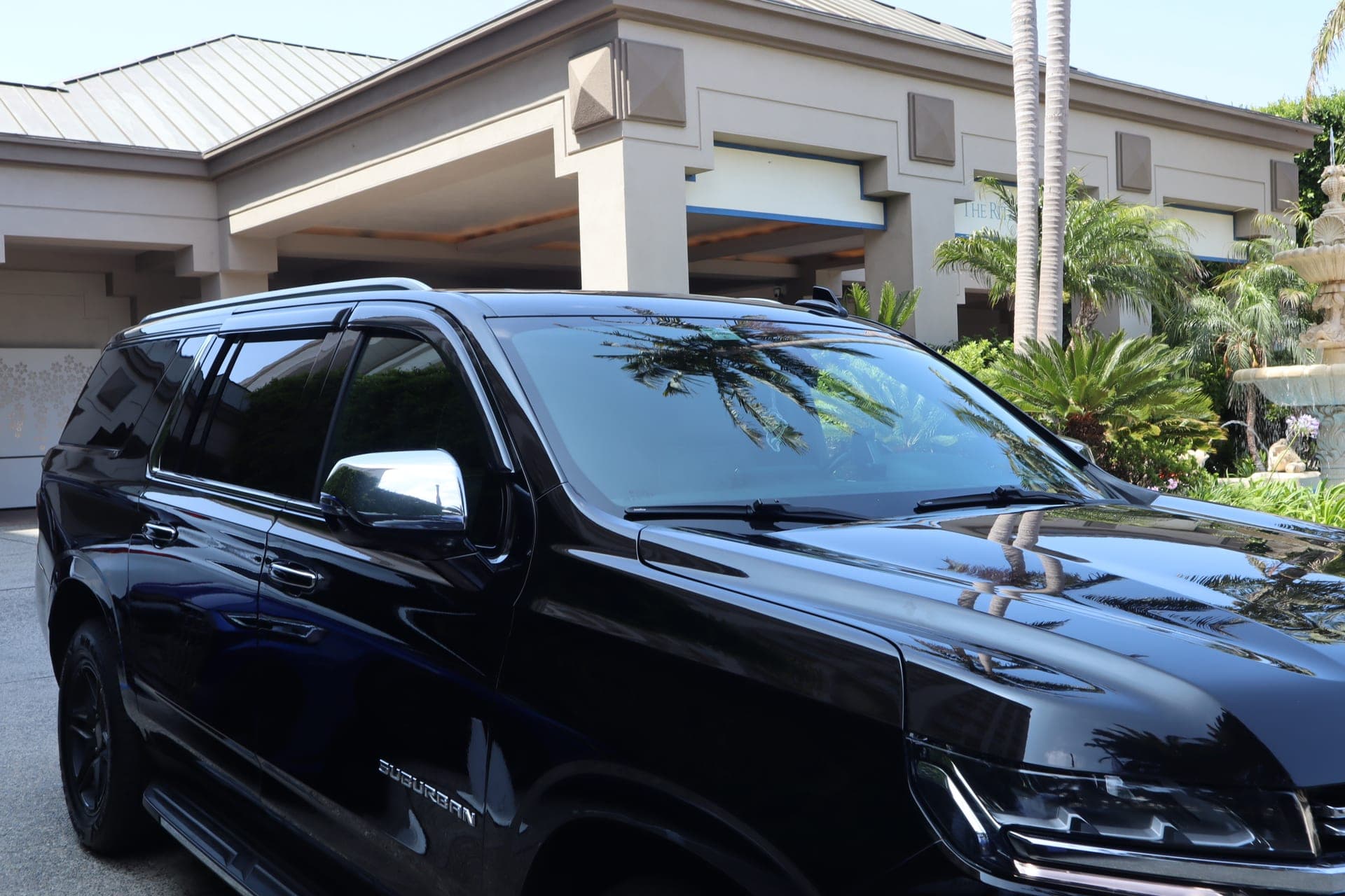 VIP City Rides black Chevrolet Suburban Premier waiting at a luxury hotel entrance in Los Angeles