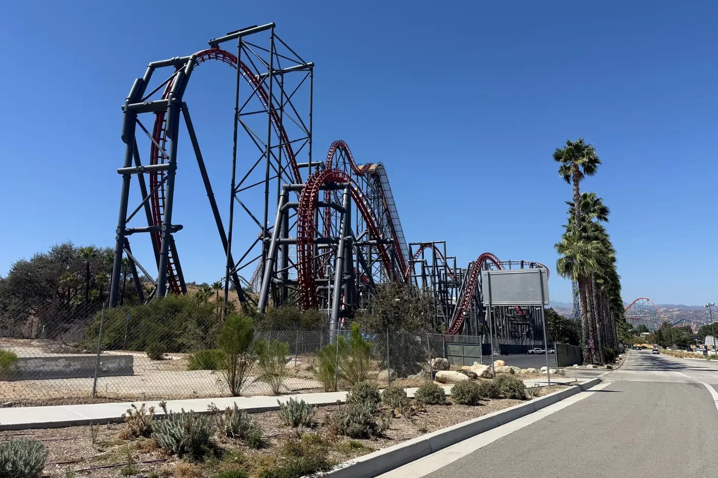 Roadside view with palm trees and roller coasters in Valencia, Santa Clarita.