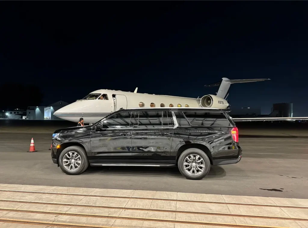VIP CITY RIDES INC classic black luxury car parked beside a private jet on the tarmac, symbolizing premium chauffeur service.
